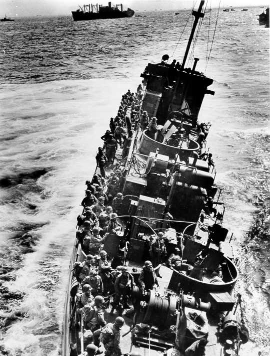The Coast Guard LCI(L)-85, battered by enemy fire after approaching Omaha Beach, prepares to evacuate the troops she was transporting to an awaiting transport.  The "85" sank shortly after this photograph was taken.  The LCI(L)-85 was one of four Coast Guard LCI's that were destroyed on D-Day. The Coast Guard LCI(L)-85, battered by enemy fire after approaching Omaha Beach, prepares to evacuate the troops she was transporting to an awaiting transport.  The "85" sank shortly after this photograph was taken.  The LCI(L)-85 was one of four Coast Guard LCI's that were destroyed on D-Day.